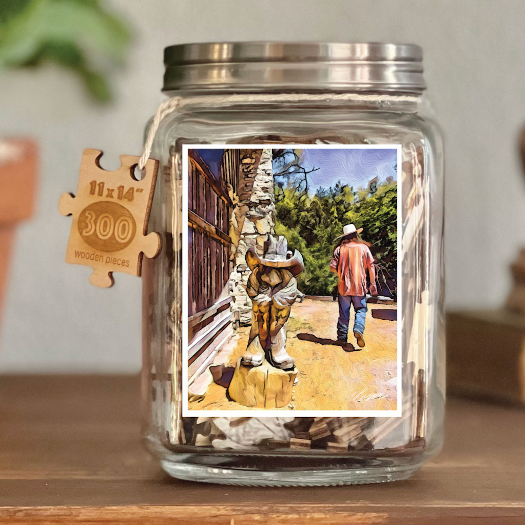 Image of puzzle shown on display clear glass Mason style jar with silver metal crew on lid. Exposes puzzle pieces inside the jar. Wooden tag hangs down the side of the jar with kite string from lid of jar with size and piece count engraved into it.